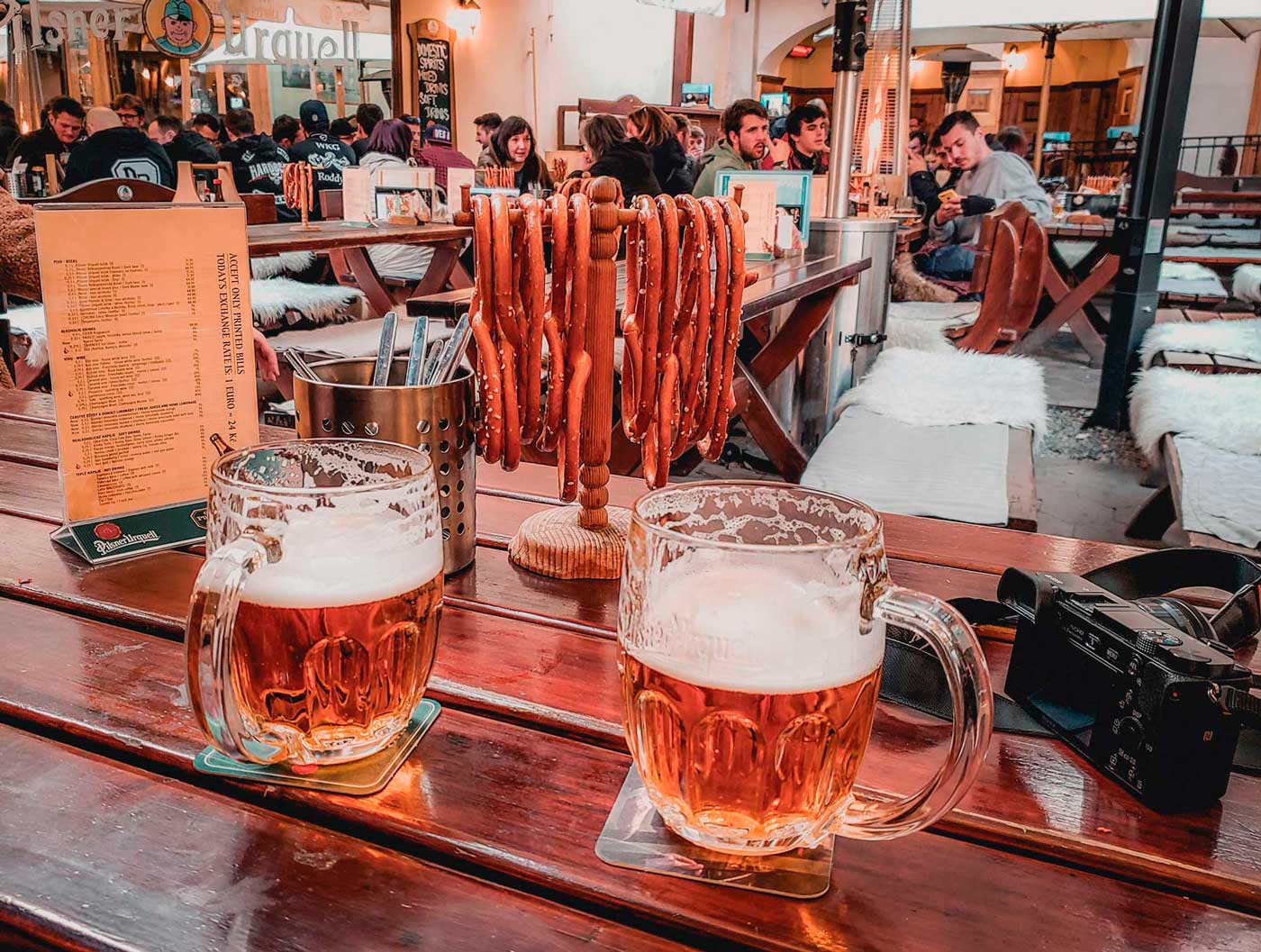 Copos de cerveja e pretzel no Vojanův Dvůr Bar Praga